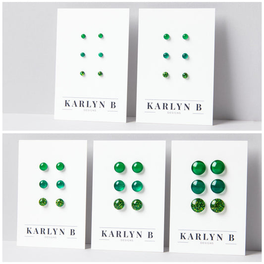 Five sets of stud earrings on white cards with the text "KARLYN B DESIGNS". Each set features three pairs of earrings in different shades of green.